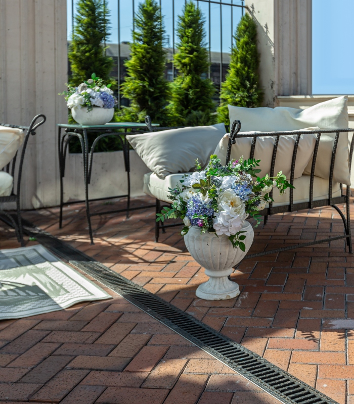 Terrasse extérieure en pavage brique avec mobilier de jardin et aménagement paysager